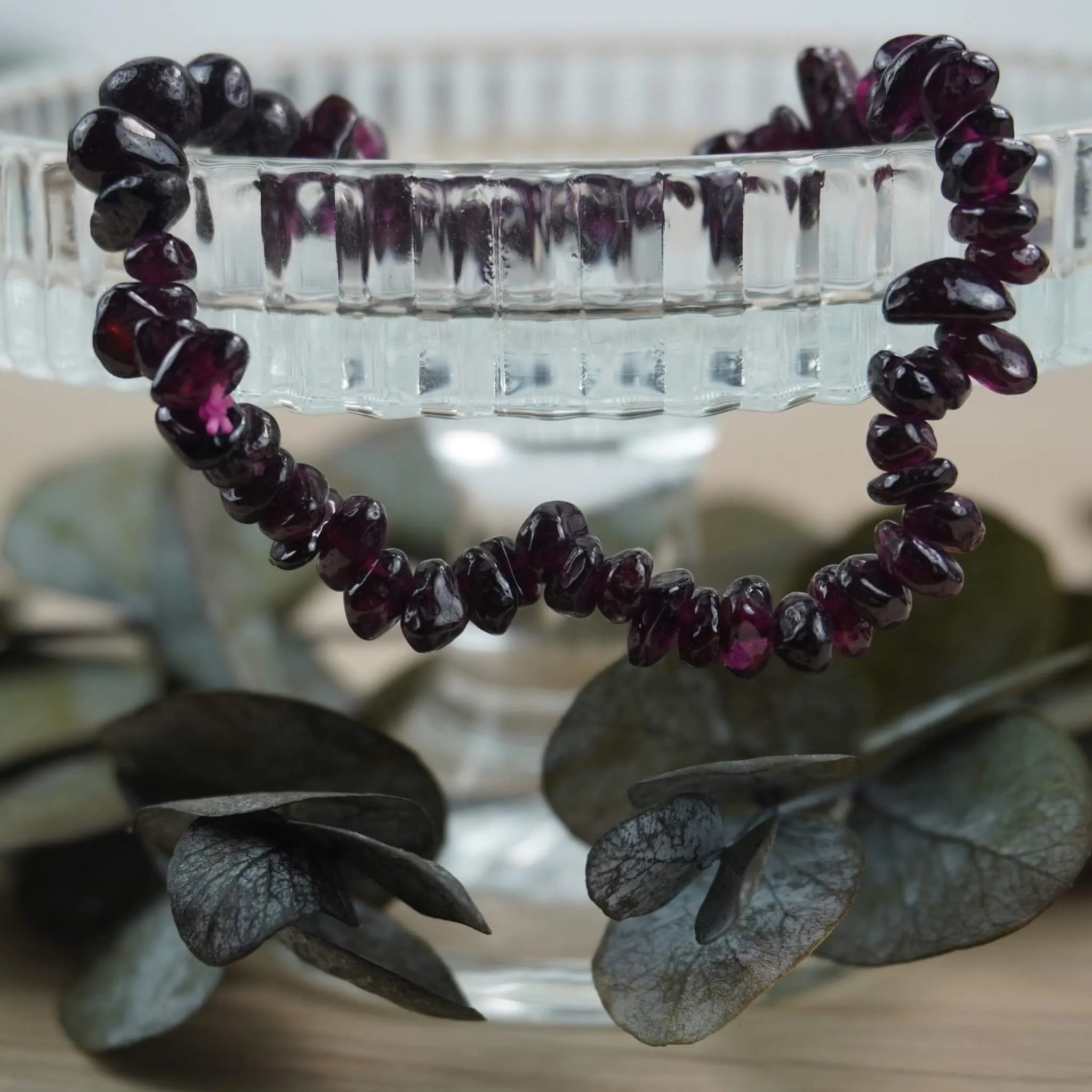 Granat Splitterarmband auf Glas-Schale mit Eukalyptus stilvoll dekoriert