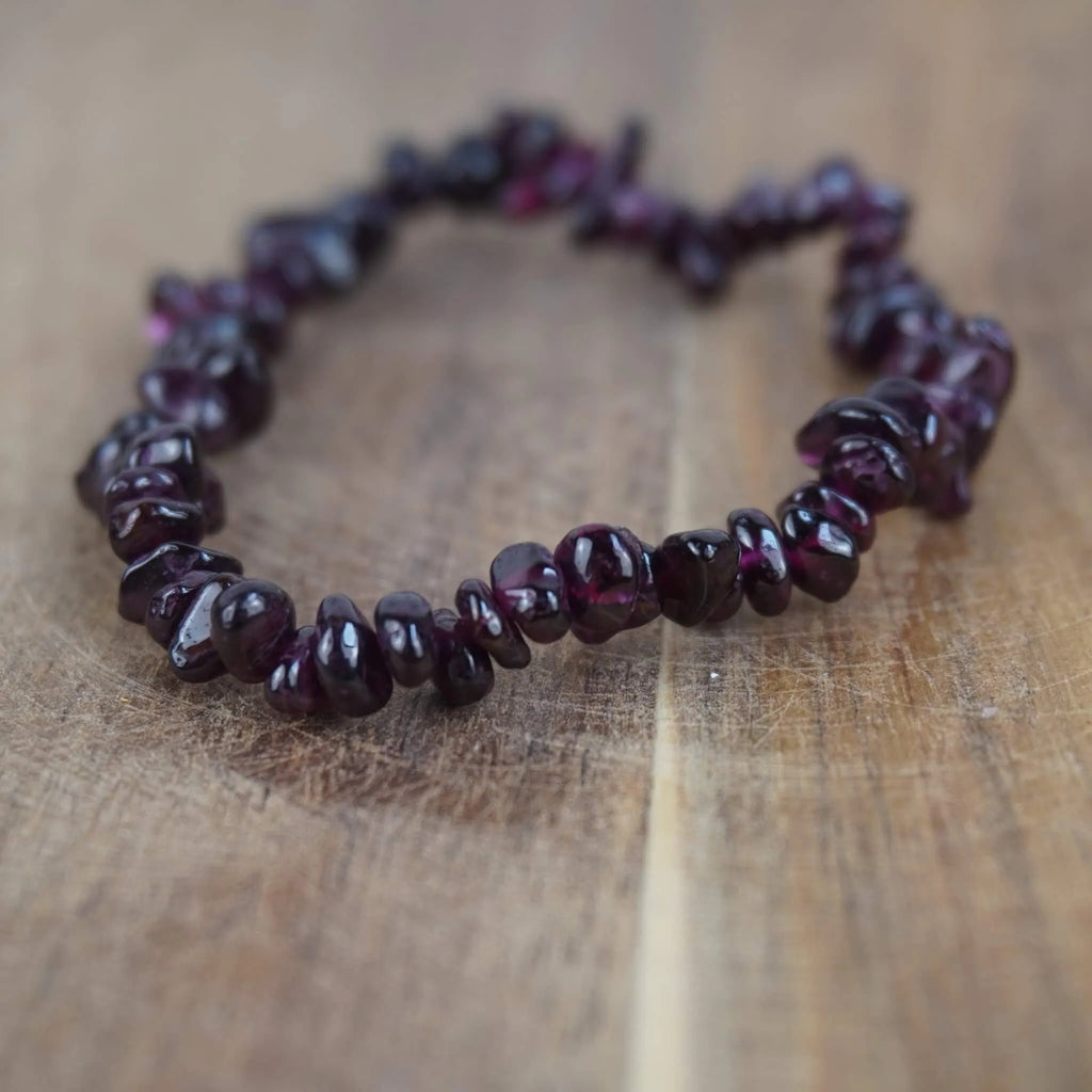 Granat Splitterarmband auf warmer Holzoberfläche im Nahaufnahme-Detail