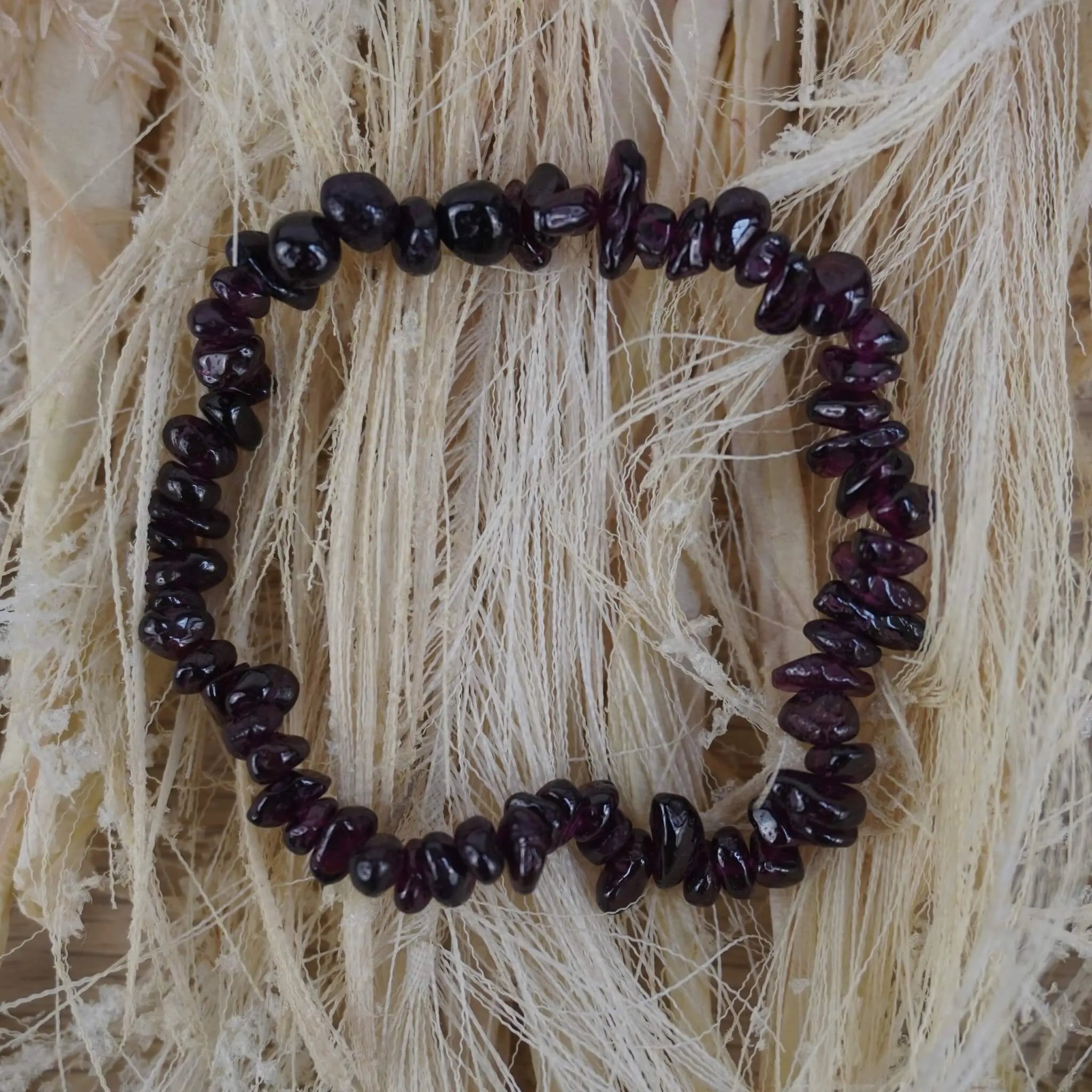 Granat Splitterarmband auf hellem Naturfaserdekor mit sichtbarer Struktur