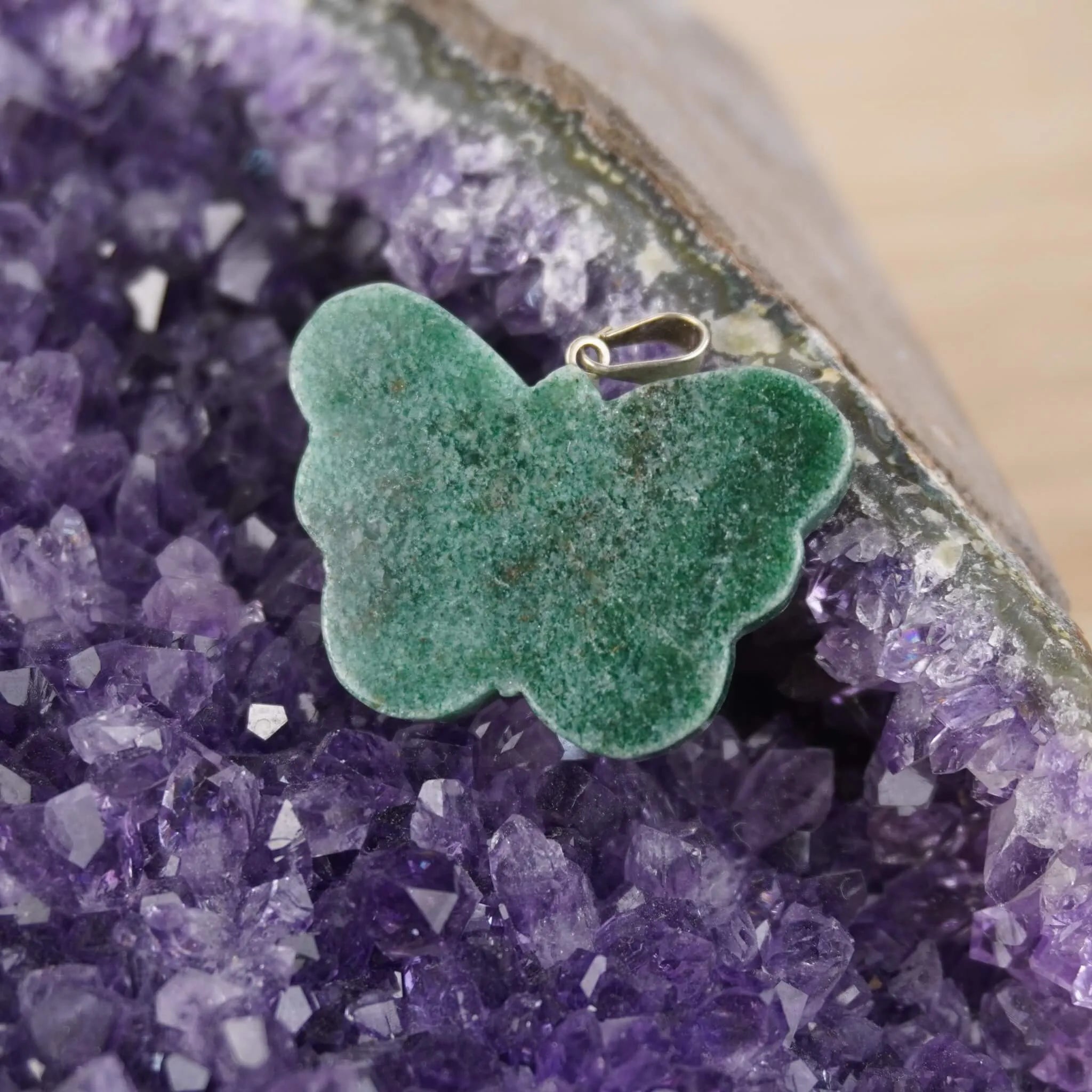 Grüner Aventurin Schmetterling Kettenanhänger präsentiert auf violetter Amethyst-Druse