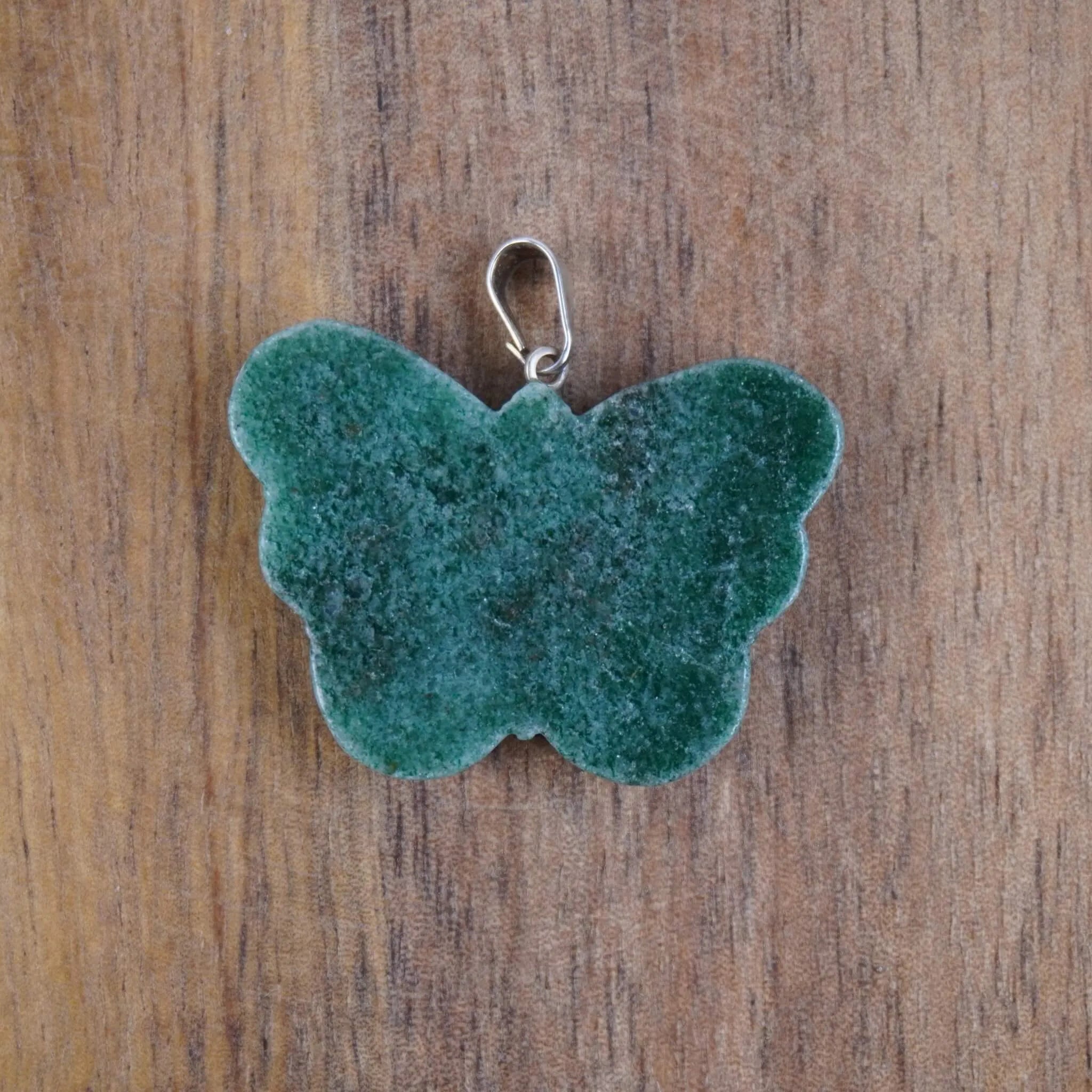 Grüner Aventurin Schmetterling Kettenanhänger vor Holzuntergrund