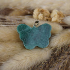 Grüner Aventurin Schmetterling Kettenanhänger auf beigen Trockenpflanzen dekoriert