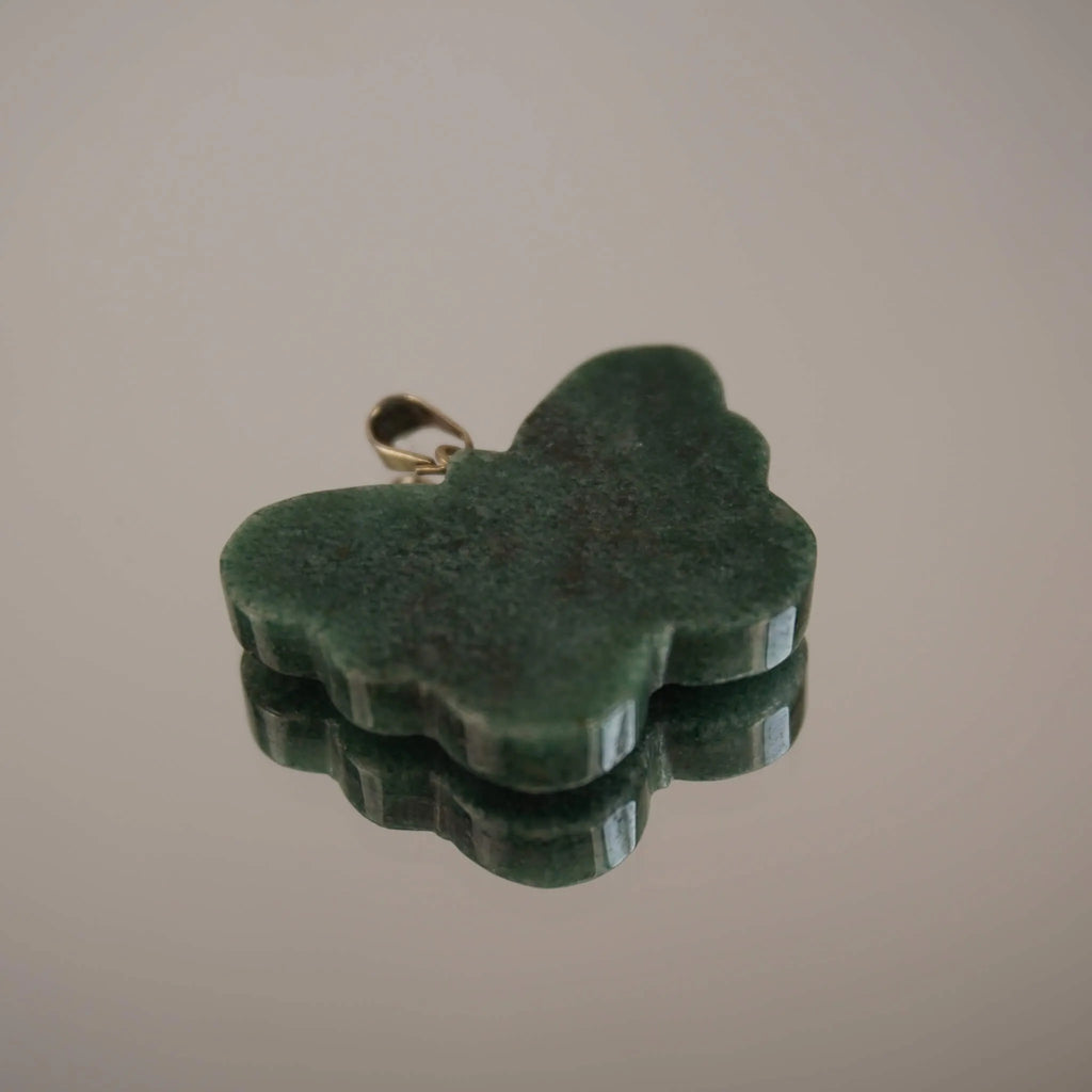 Grüner Aventurin Schmetterling Kettenanhänger mit silberner Öse und Spiegelung auf glänzender Fläche