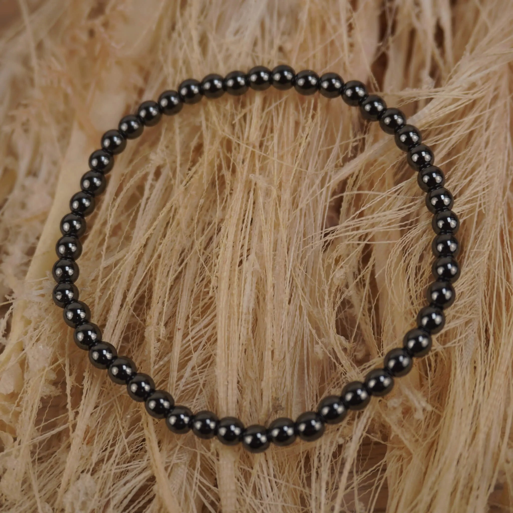 Hämatit Kugelarmband auf hellem Naturfaserdekor