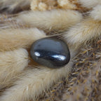 Hämatit Trommelstein dekoriert auf beigen flauschigen Ziergräsern