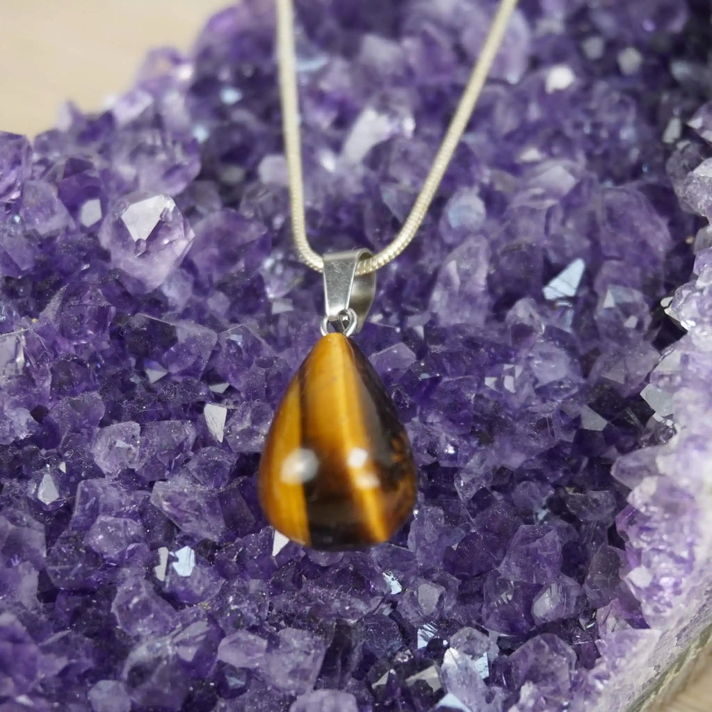 Tropfenförmiger Tigerauge Anhänger an 925 Silberkette auf Amethyst-Druse
