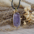 Halskette mit Amethyst Anhänger auf getrockneten Gräsern