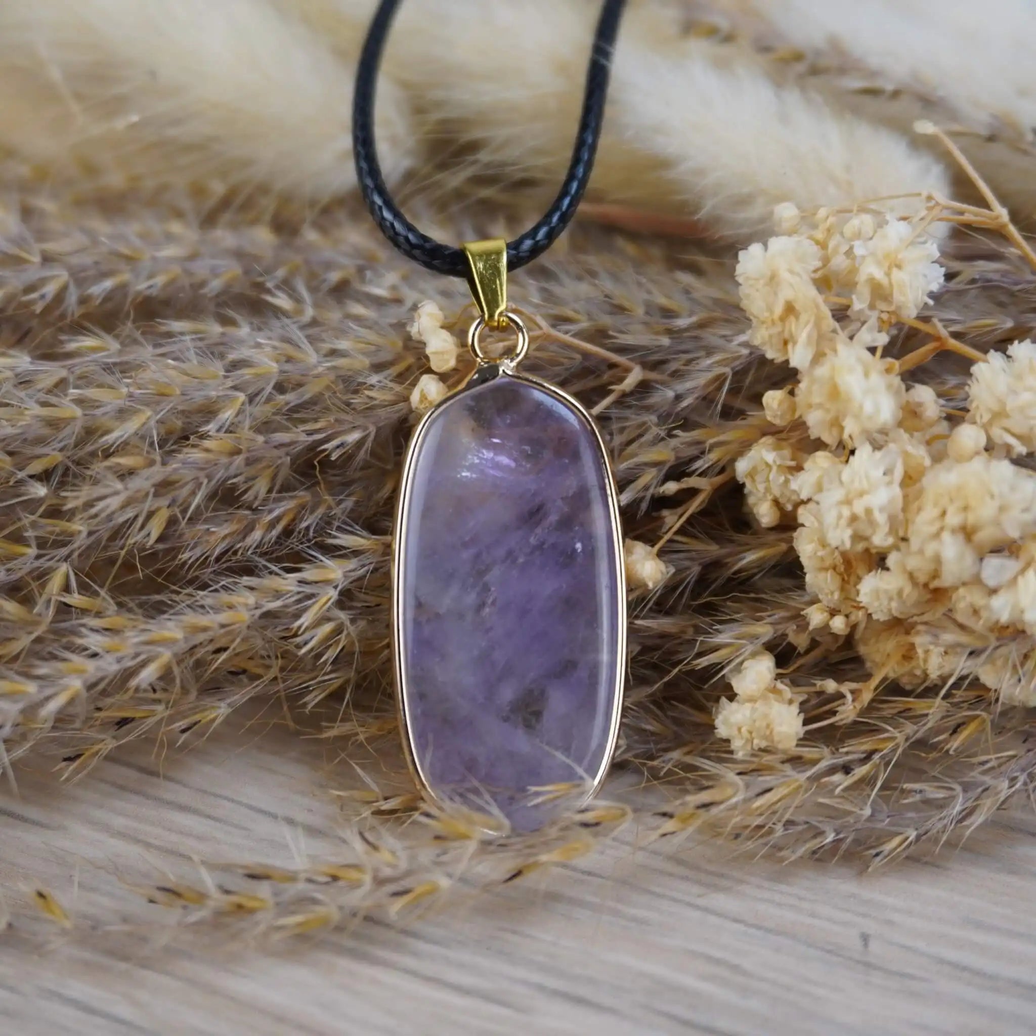 Halskette mit Amethyst Anhänger auf getrockneten Gräsern