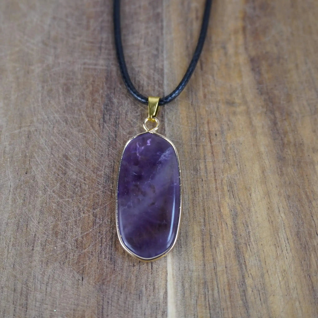 Halskette mit Amethyst Anhänger auf Holzunterlage