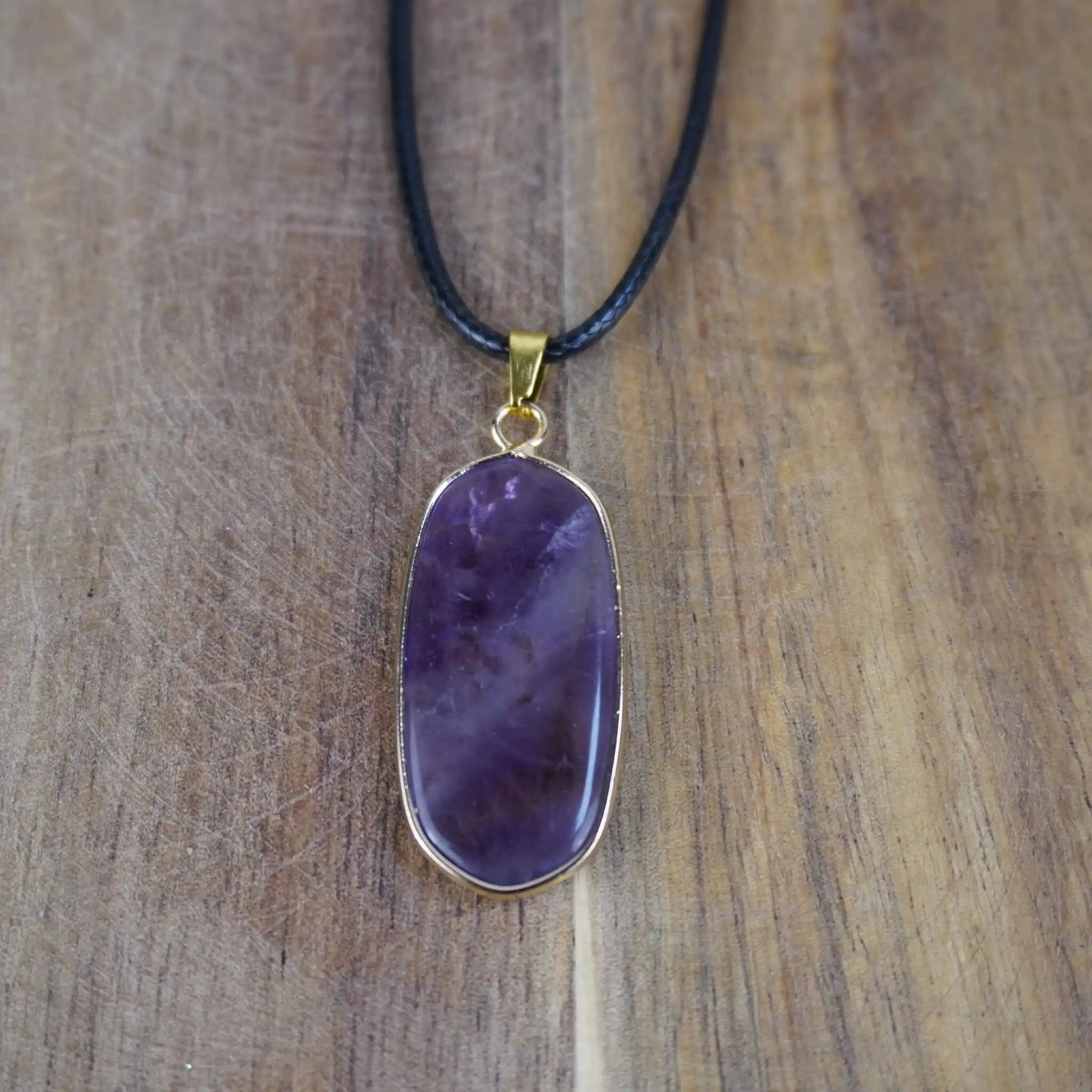 Halskette mit Amethyst Anhänger auf Holzunterlage
