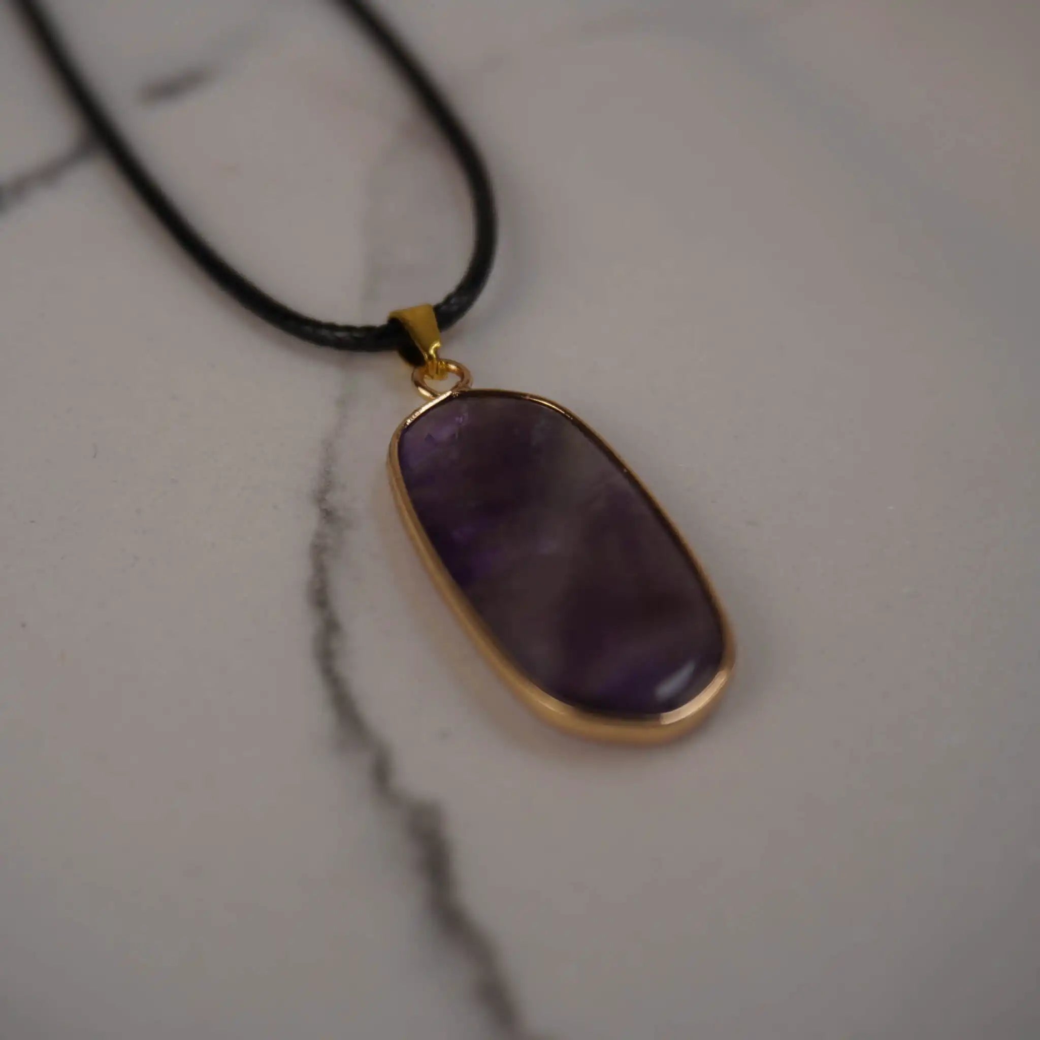 Halskette mit Amethyst Anhänger auf Marmoruntergrund