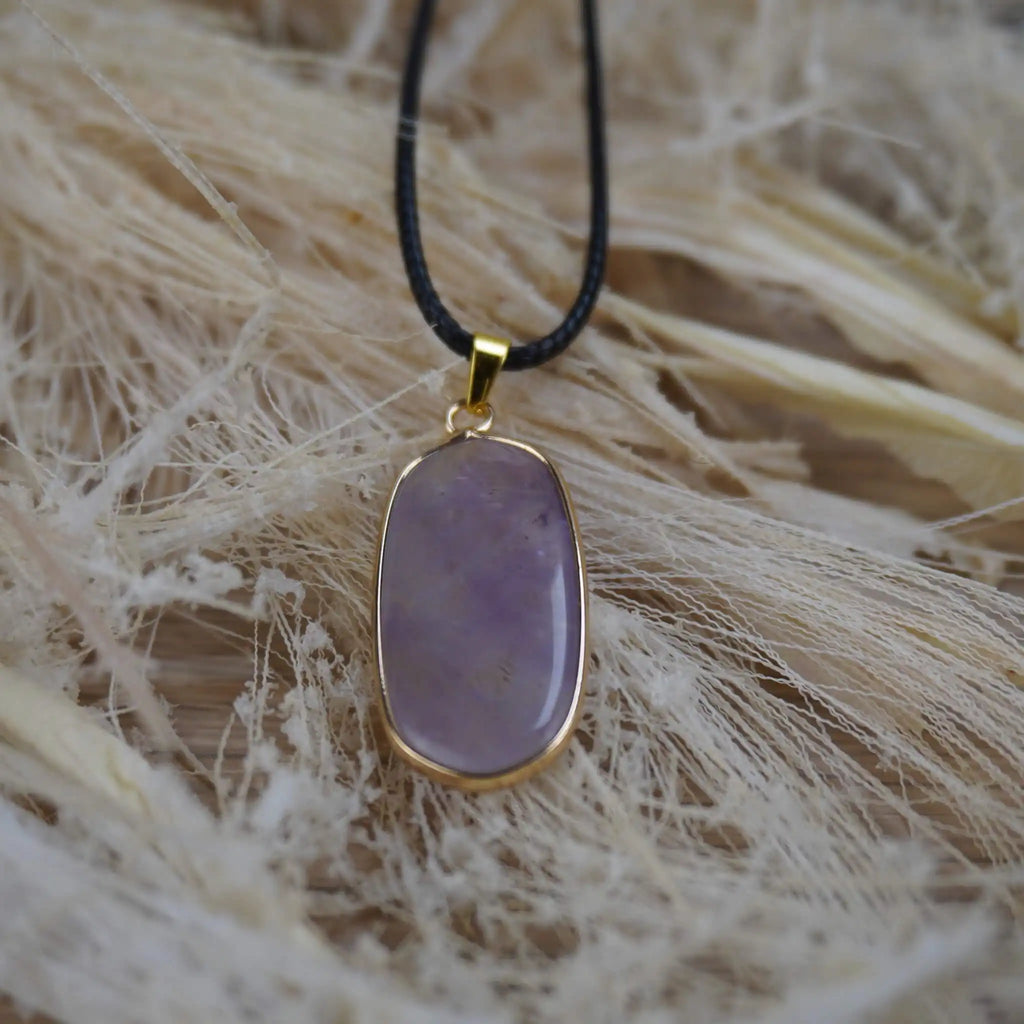 Halskette mit Amethyst Anhänger auf Naturfaser-Hintergrund