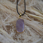 Halskette mit Amethyst Anhänger auf Naturfaser-Hintergrund