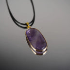 Halskette mit Amethyst Anhänger auf Spiegelunterlage