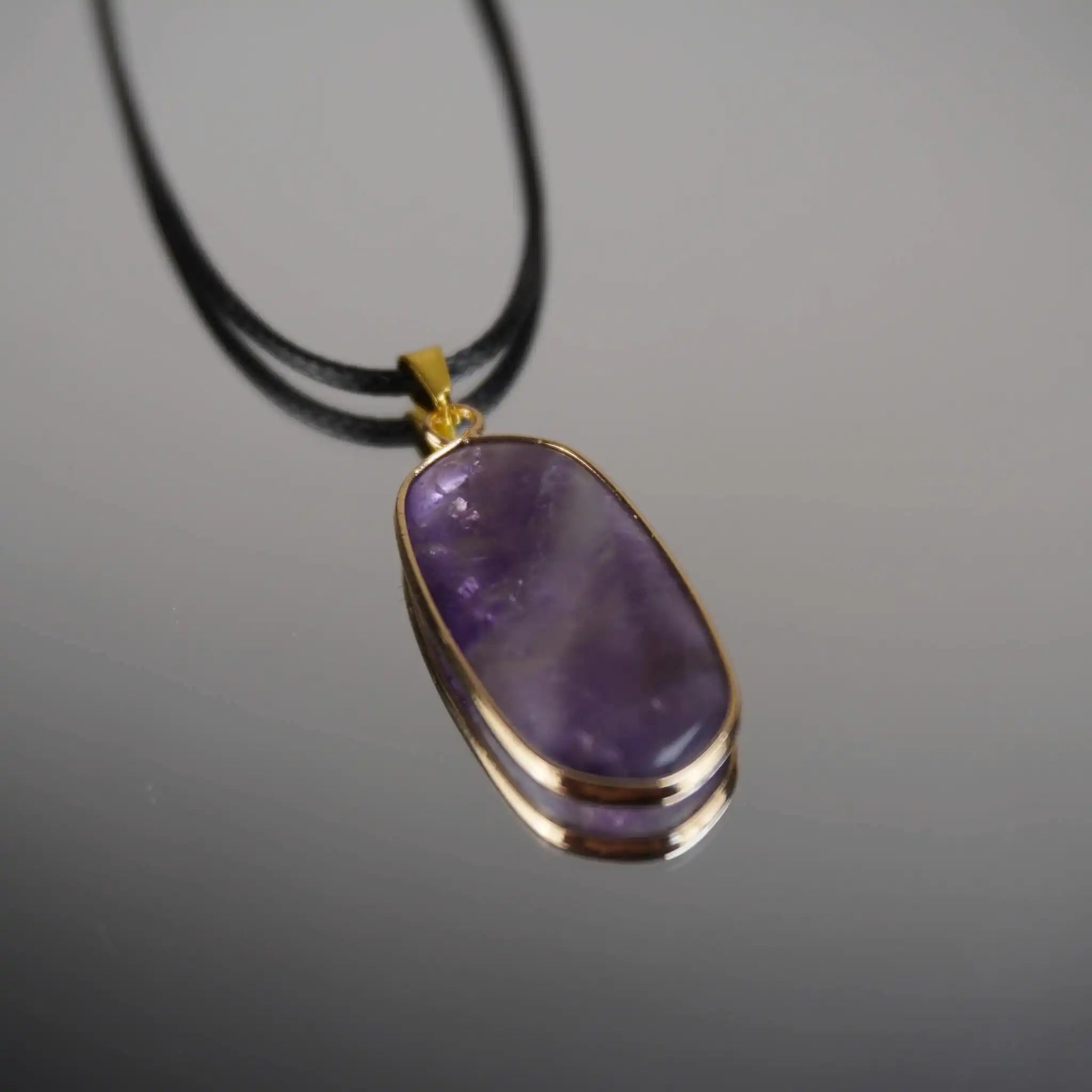 Halskette mit Amethyst Anhänger auf Spiegelunterlage