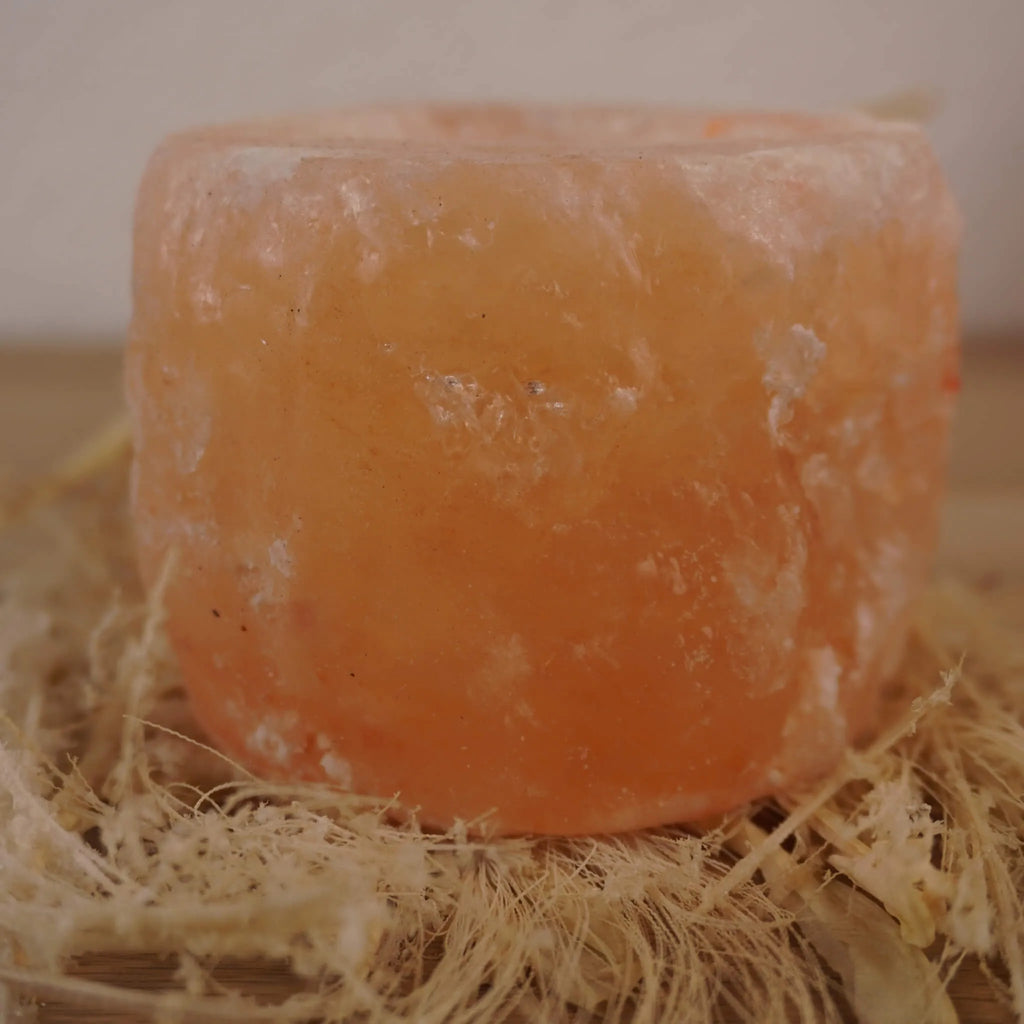 Himalaya Salzkristall Kerzenhalter auf hellen Naturfasern arrangiert