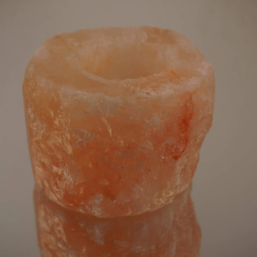Himalaya Salzkristall Kerzenhalter mit Spiegelung auf glänzender Fläche