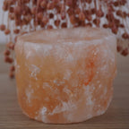 Himalaya Salzkristall Kerzenhalter vor rosa getrockneten Gräsern