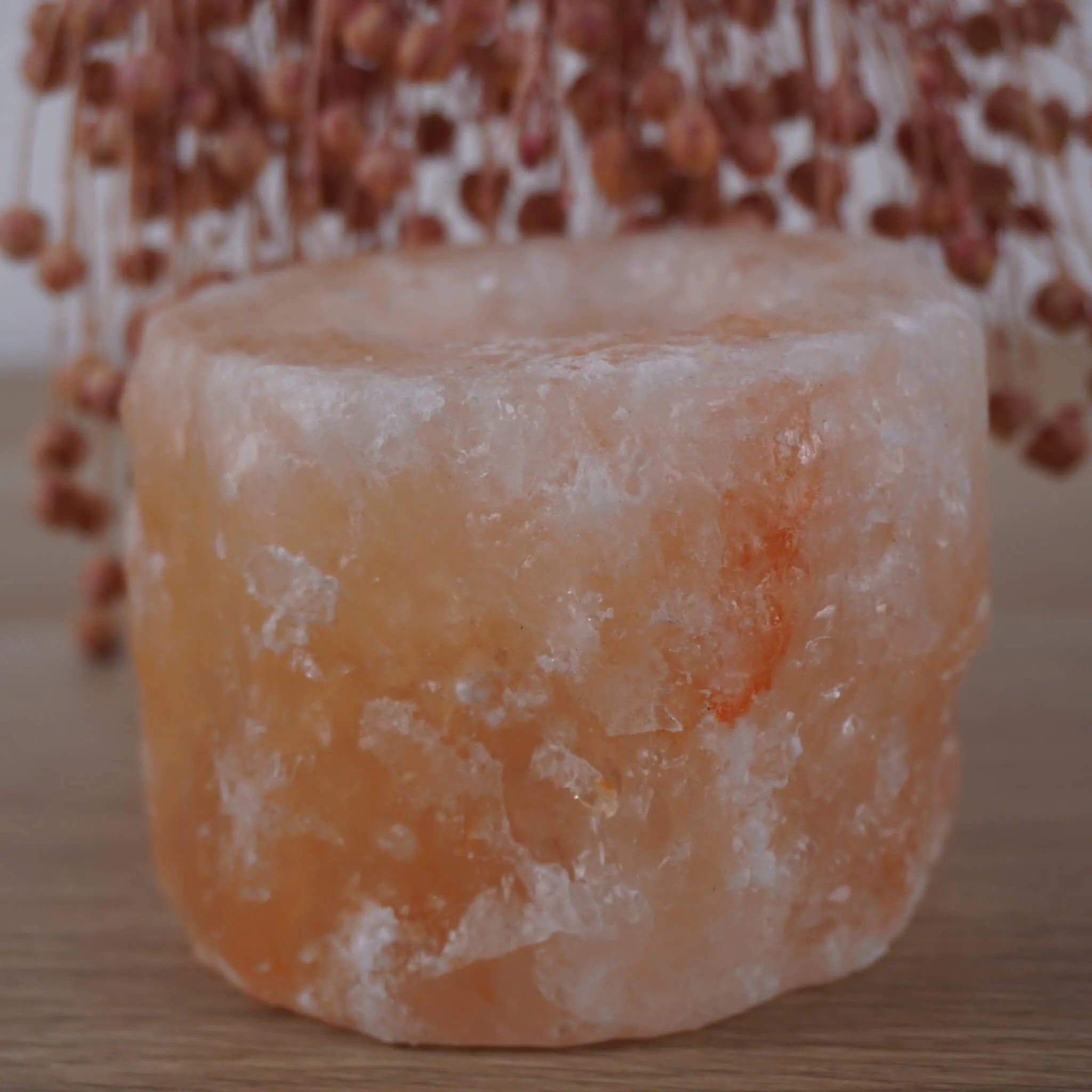 Himalaya Salzkristall Kerzenhalter vor rosa getrockneten Gräsern