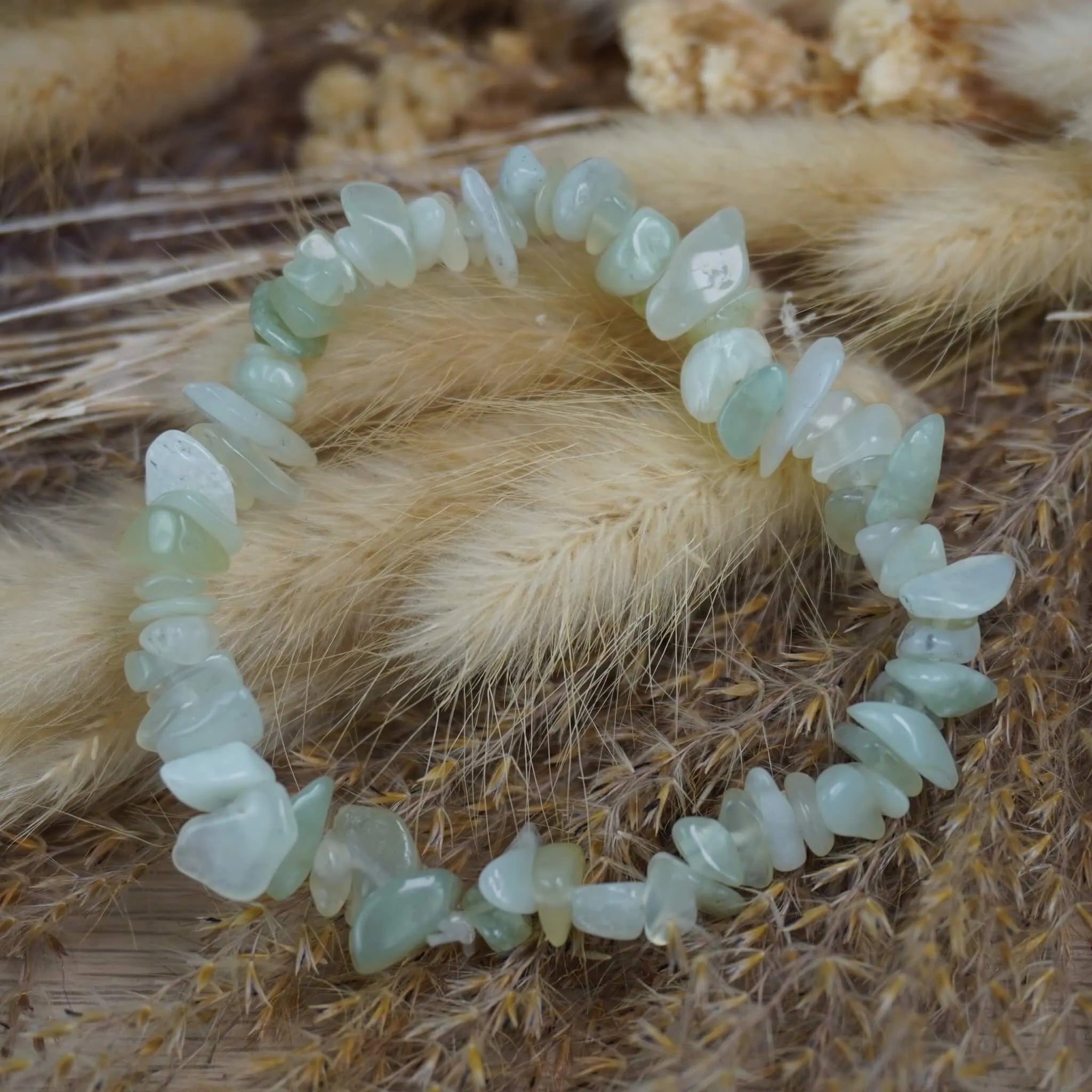 Jade Splitterarmband auf beigen Trockenblumen im natürlichen Boho-Stil