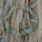 Jade Splitterarmband auf hellem Naturfaserdekor mit feiner Struktur