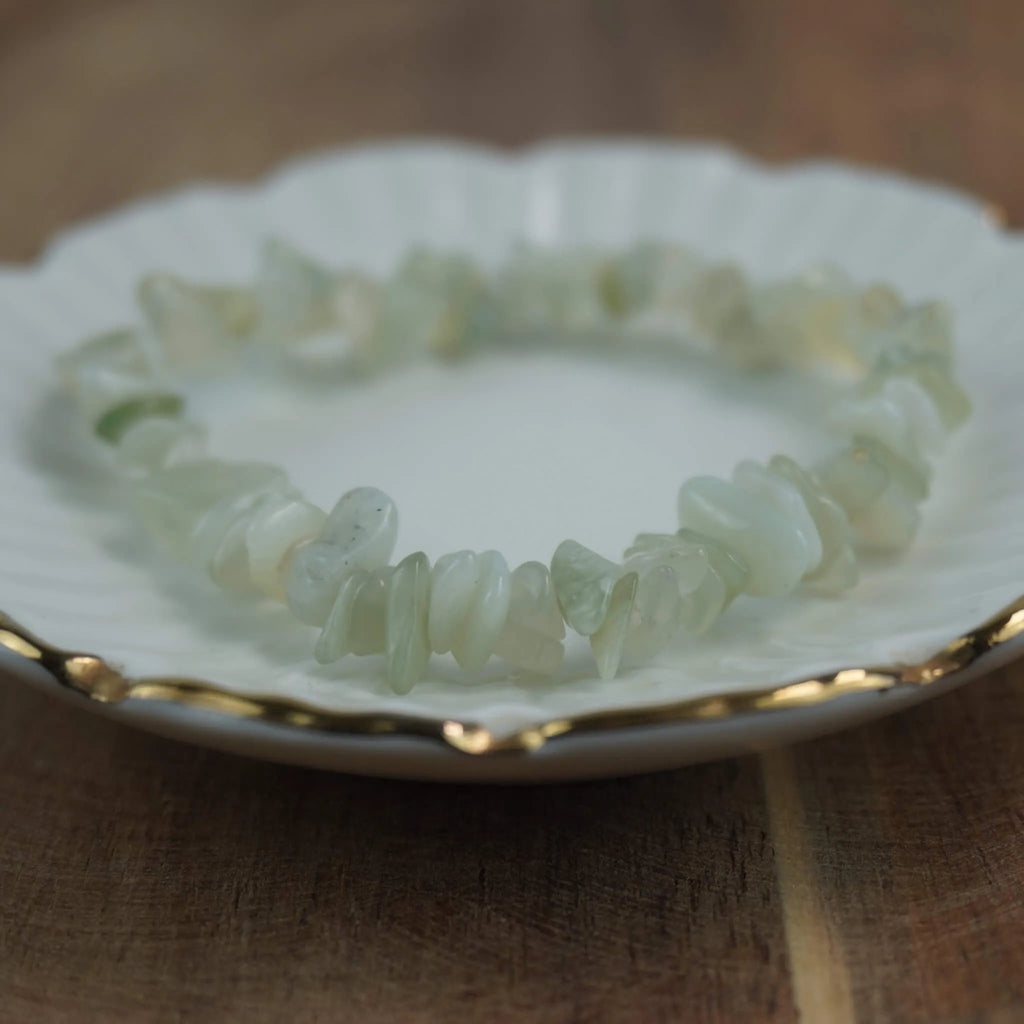 Jade Splitterarmband liegt auf weißem Teller mit feinem Goldrand