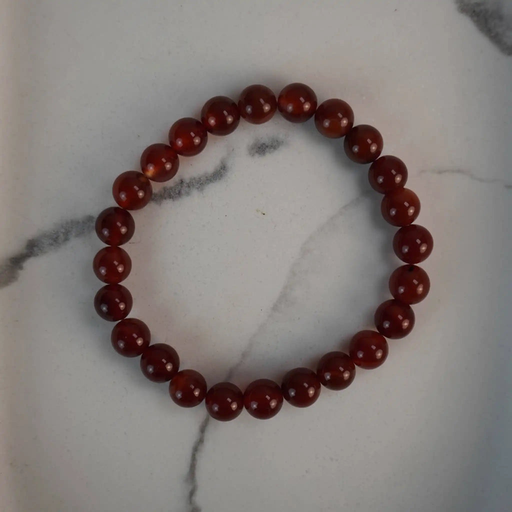 Karneol Kugelarmband auf weißem Marmor-Hintergrund