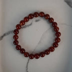Karneol Kugelarmband auf weißem Marmor-Hintergrund
