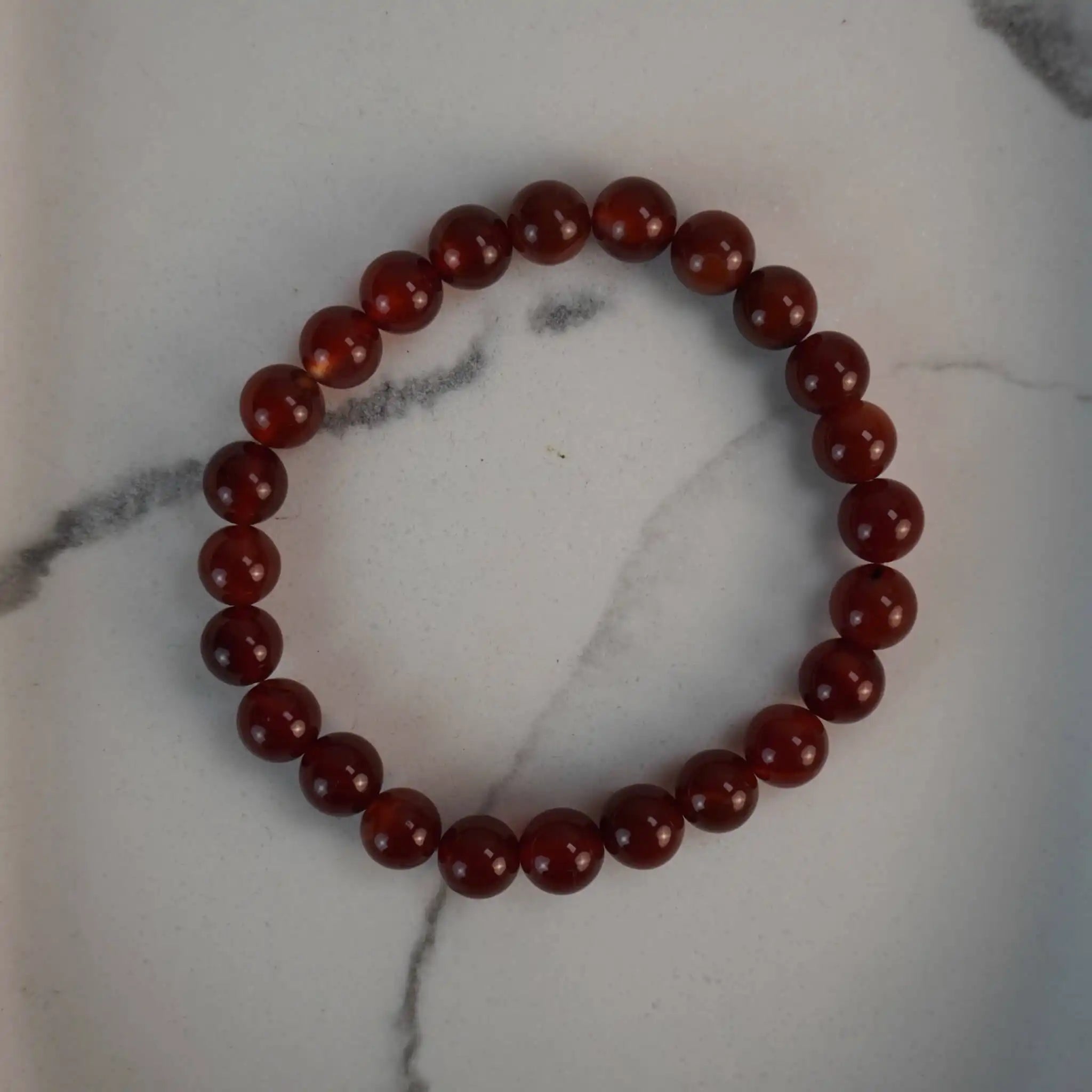 Karneol Kugelarmband auf weißem Marmor-Hintergrund