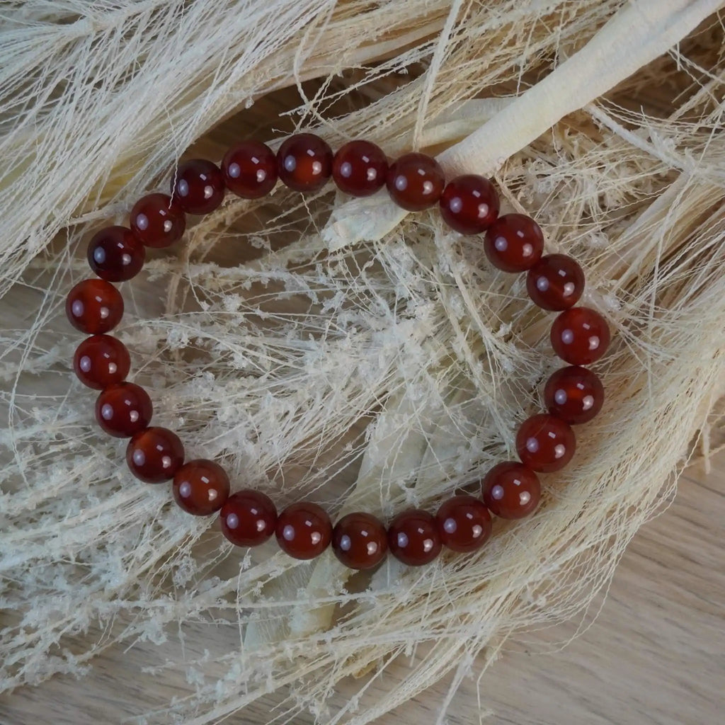 Karneol Kugelarmband auf hellen Naturmaterialien