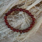 Karneol Kugelarmband auf hellen Naturmaterialien