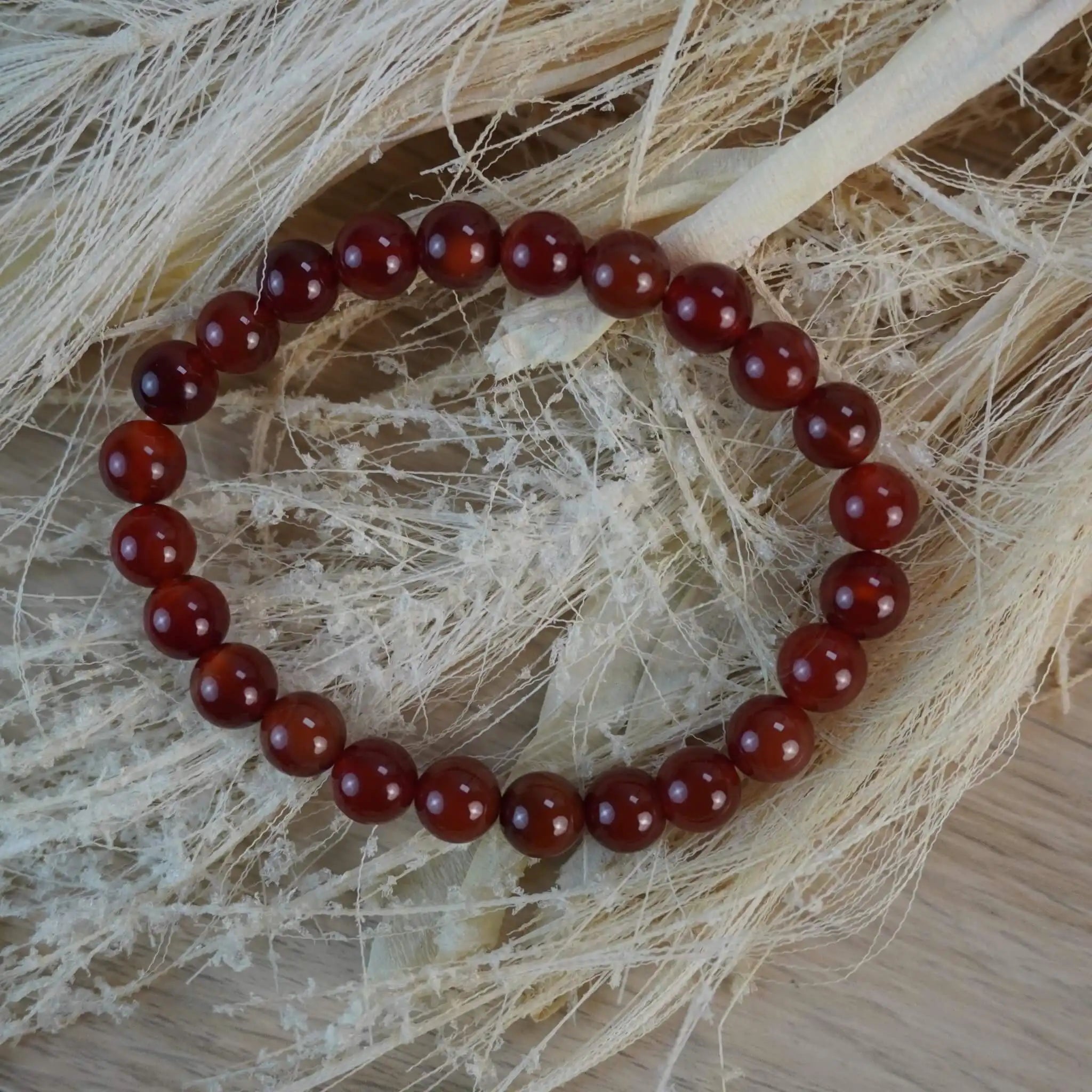Karneol Kugelarmband auf hellen Naturmaterialien