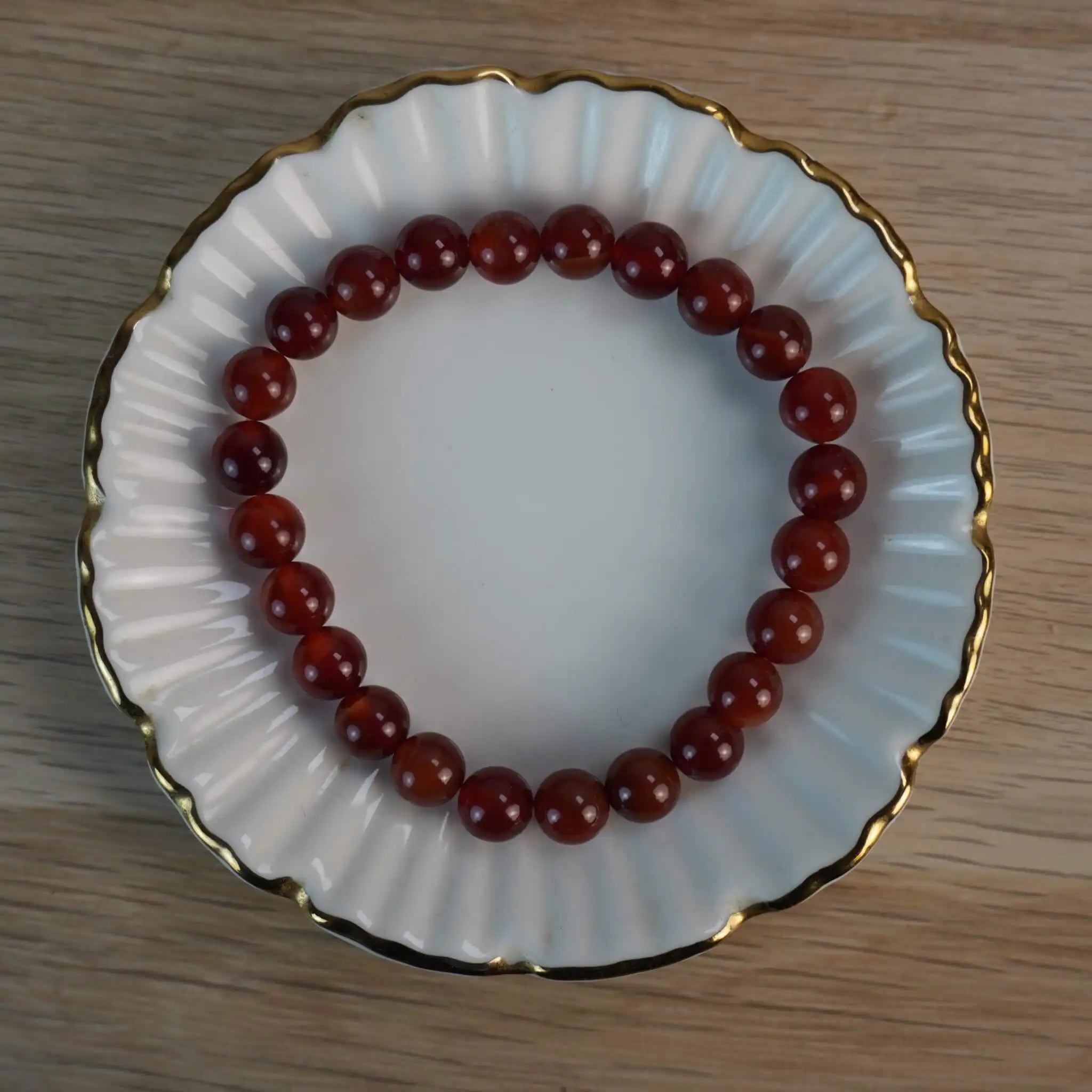 Karneol Kugelarmband auf weißer Porzellanschale