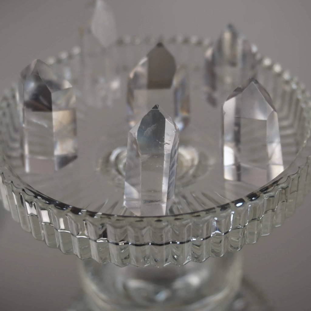 Mehrere klare Bergkristall Spitzen auf einem erhöhten Glaskelch arrangiert