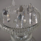 Mehrere klare Bergkristall Spitzen auf einem erhöhten Glaskelch arrangiert