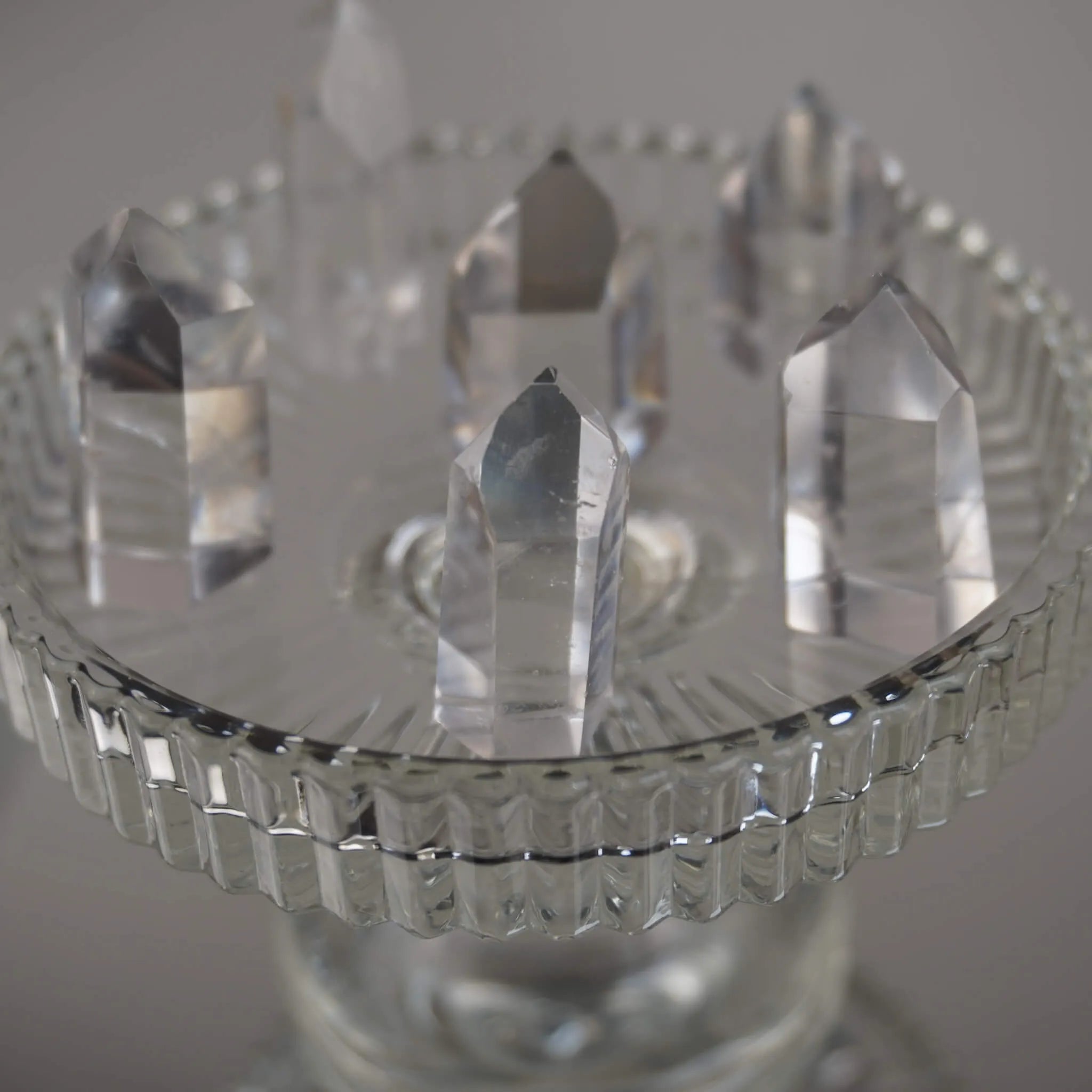 Mehrere klare Bergkristall Spitzen auf einem erhöhten Glaskelch arrangiert