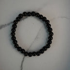 Kugelarmband aus Onyx, Obsidian und Turmalin auf Marmoroberfläche