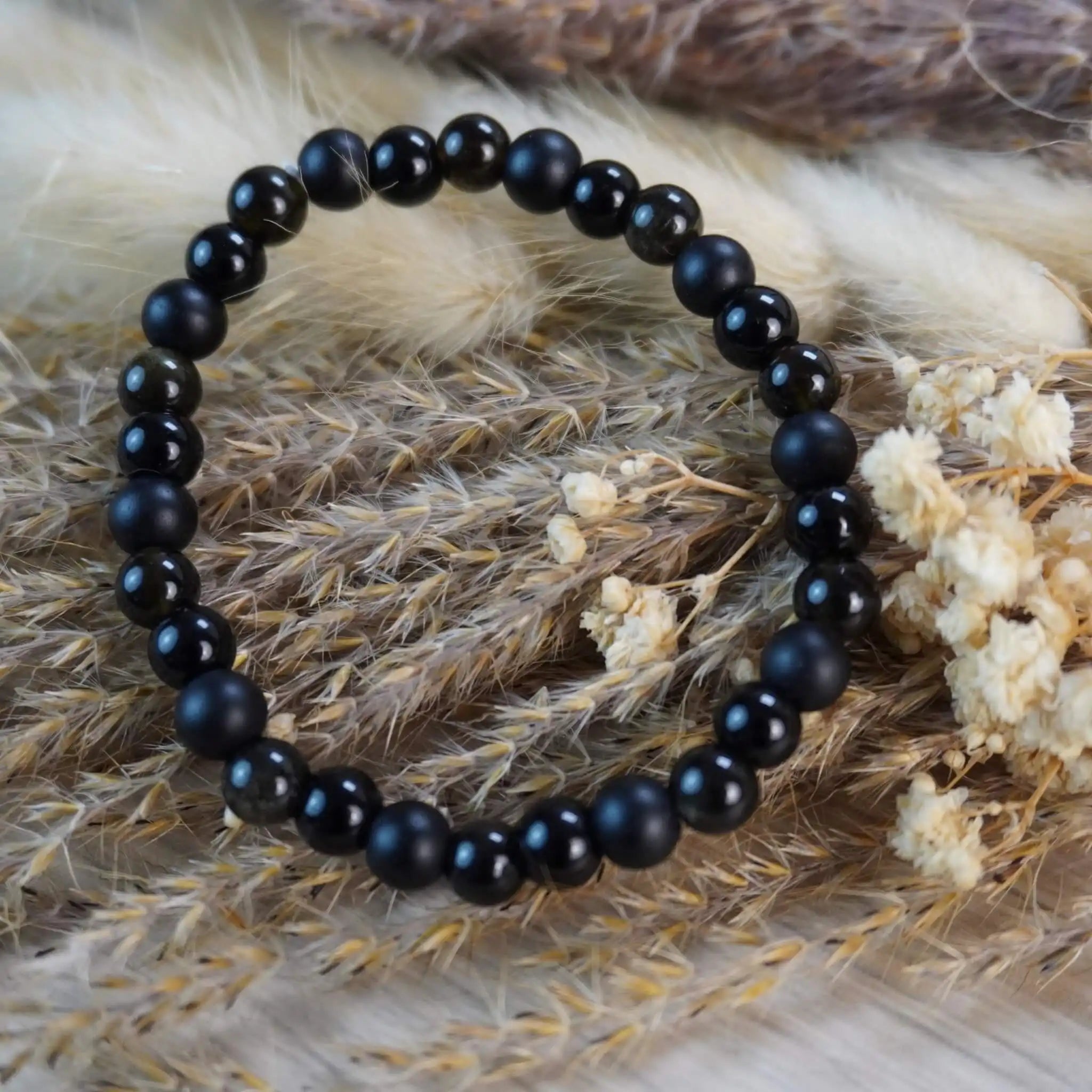 Kugelarmband aus Onyx, Obsidian und Turmalin auf Naturdeko mit Trockenblumen