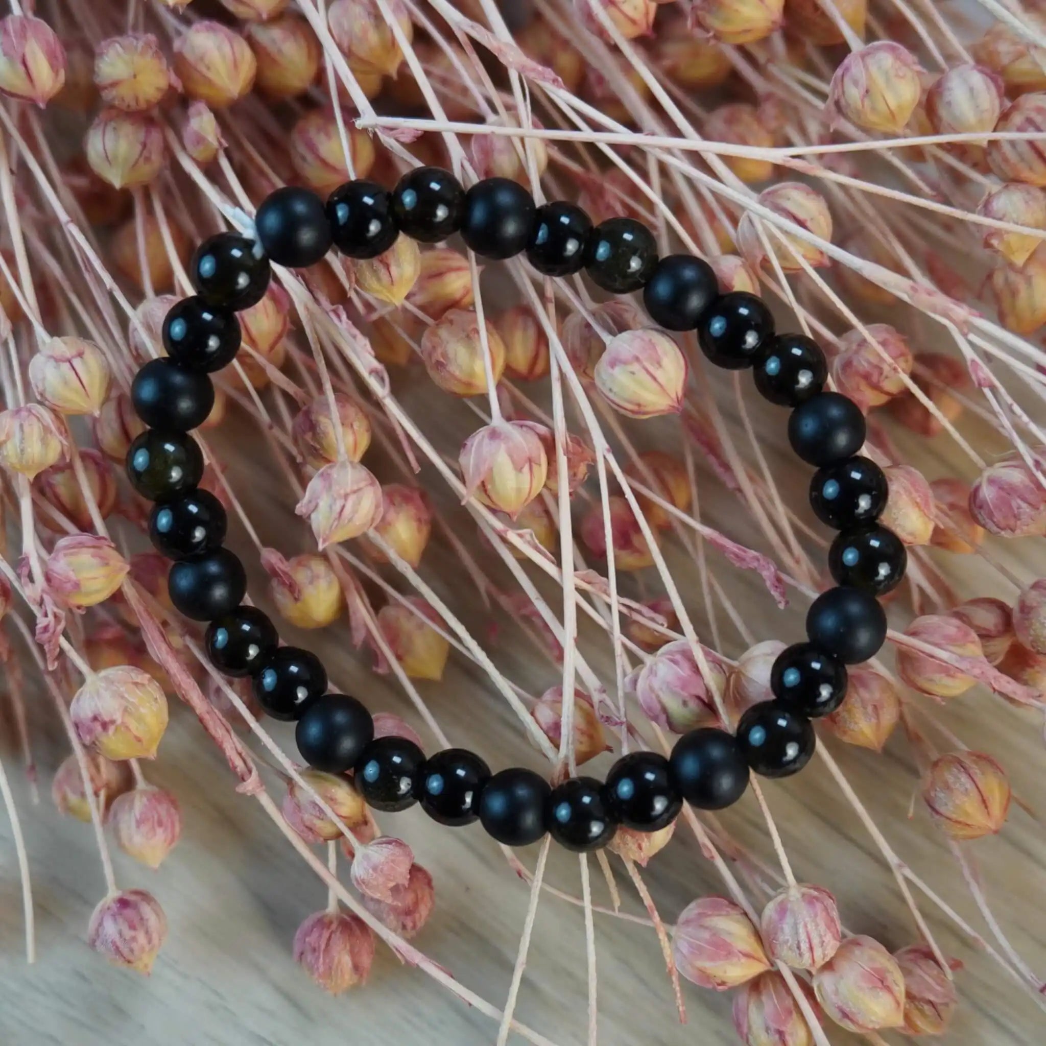 Kugelarmband aus Onyx, Obsidian und Turmalin auf bunten Trockenblumen
