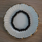 Schwarzes Kugelarmband aus Onyx, Obsidian und Turmalin in dekorativer Schmuckschale