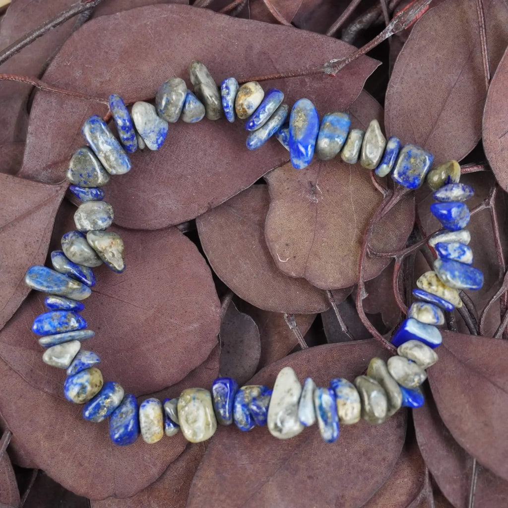 Lapislazuli‑Splitterarmband auf violett-braunen Blättern, natürlich präsentiert