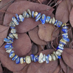 Lapislazuli‑Splitterarmband auf violett-braunen Blättern, natürlich präsentiert