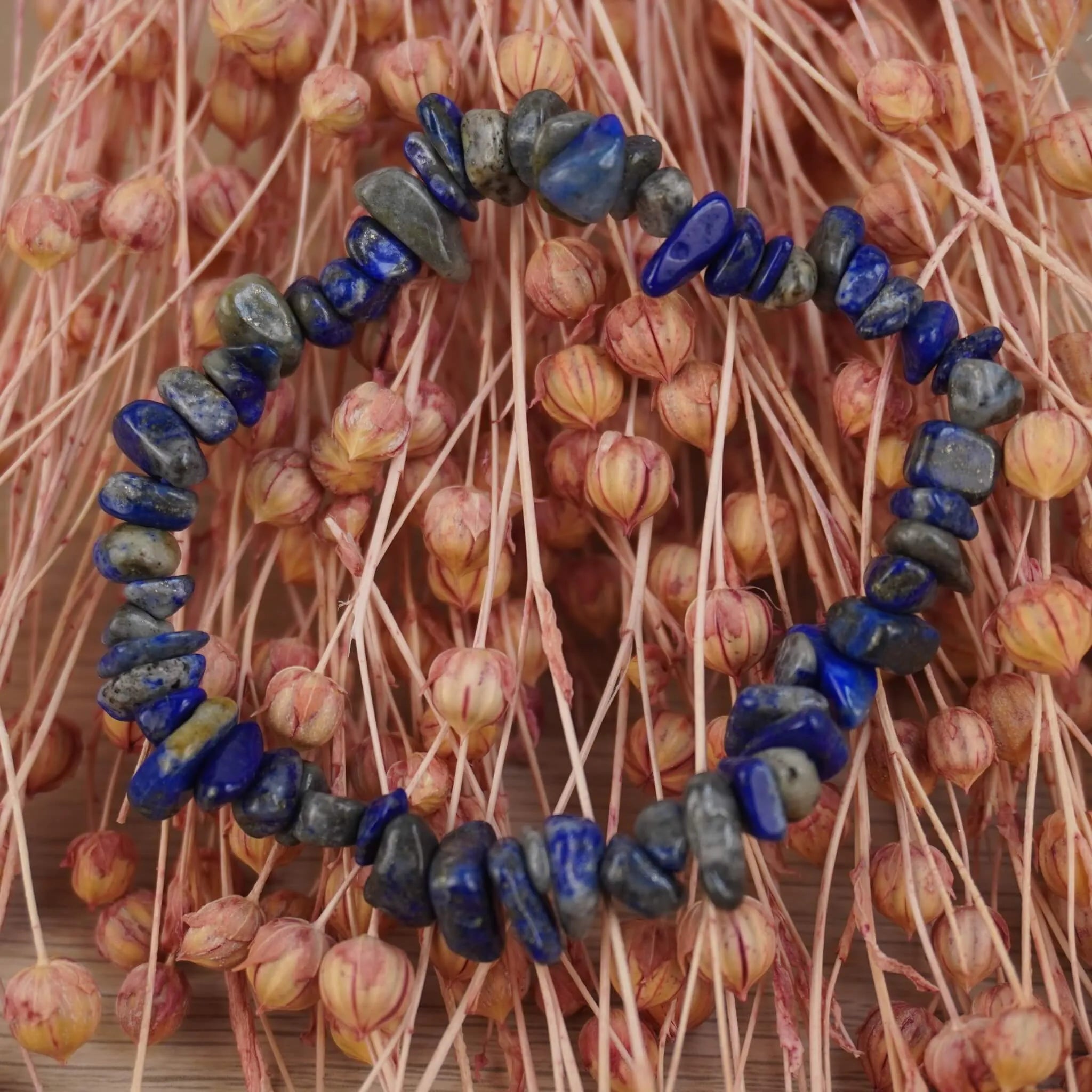 Lapislazuli‑Splitterarmband vor rosafarbenen Trockenblumen