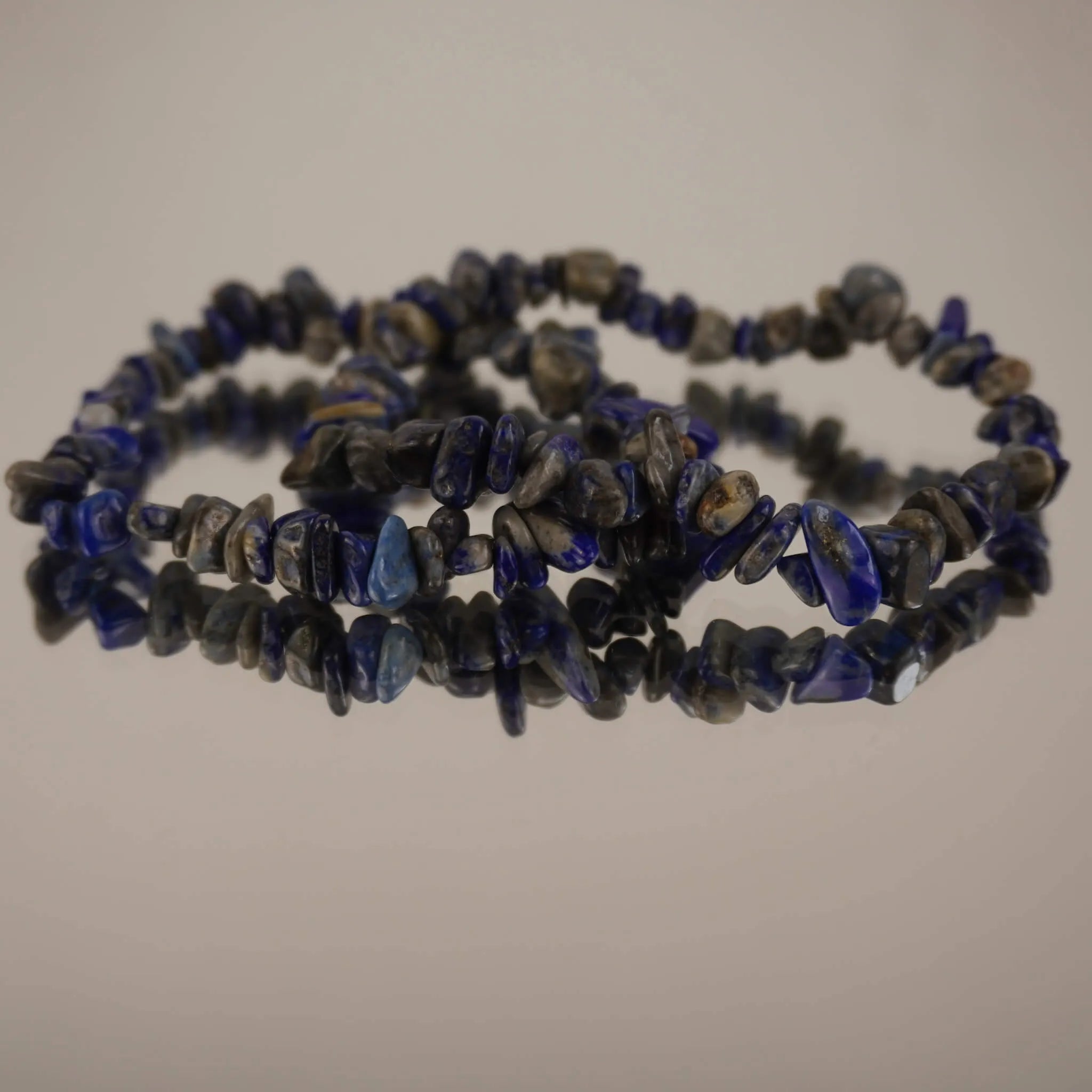 Lapislazuli‑Splitterarmband auf spiegelnder Fläche mit eleganter Reflexion