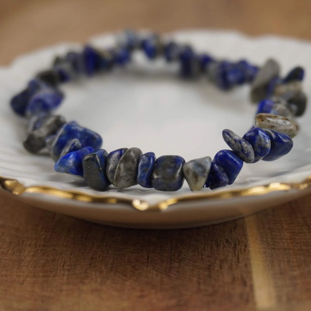 Lapislazuli‑Splitterarmband auf weißem Schmuckteller mit feinem Goldrand