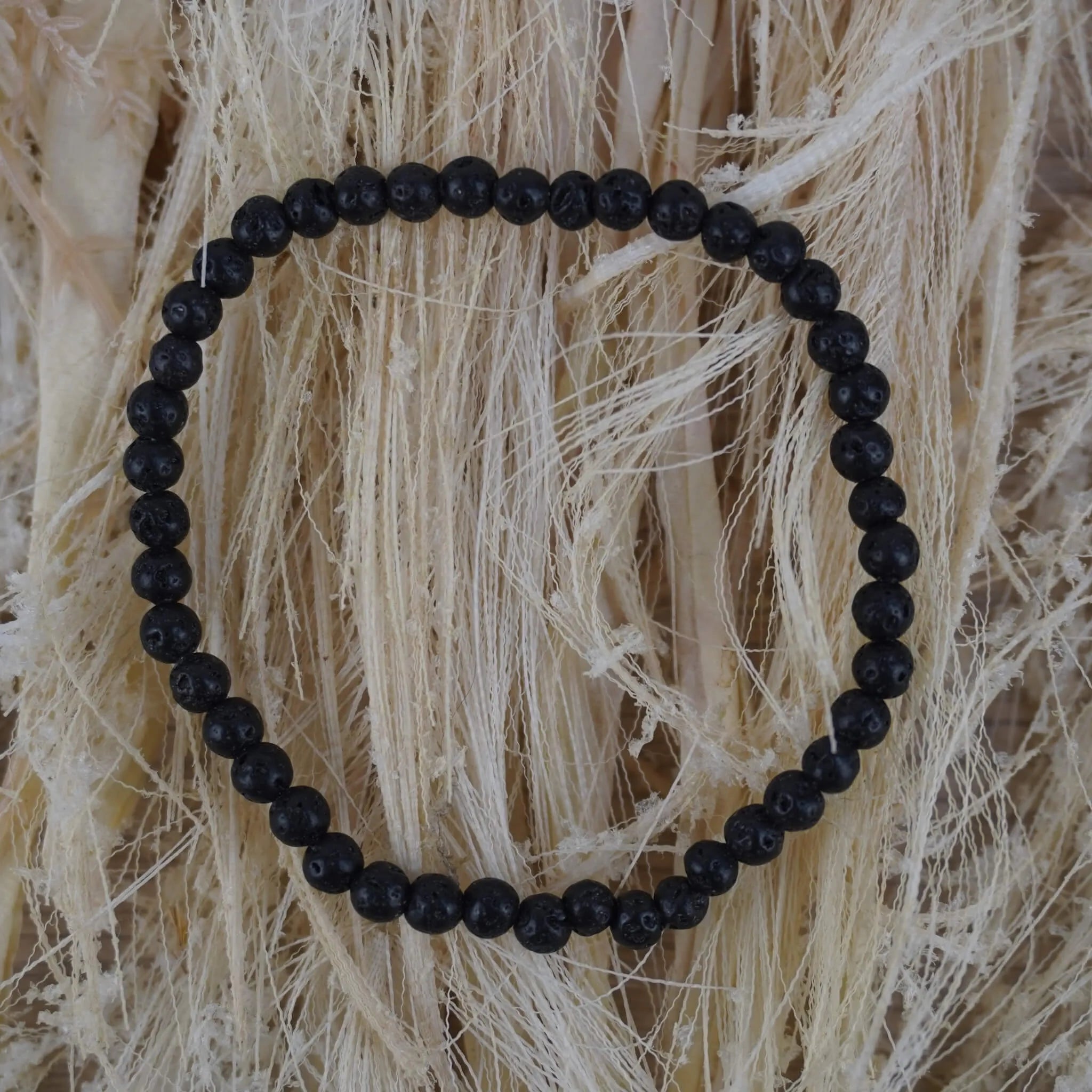 Lavastein Kugelarmband auf hellem Naturfaserdekor mit strukturierter Optik