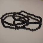 Lavastein Kugelarmband auf spiegelnder Fläche mit feiner Reflexion