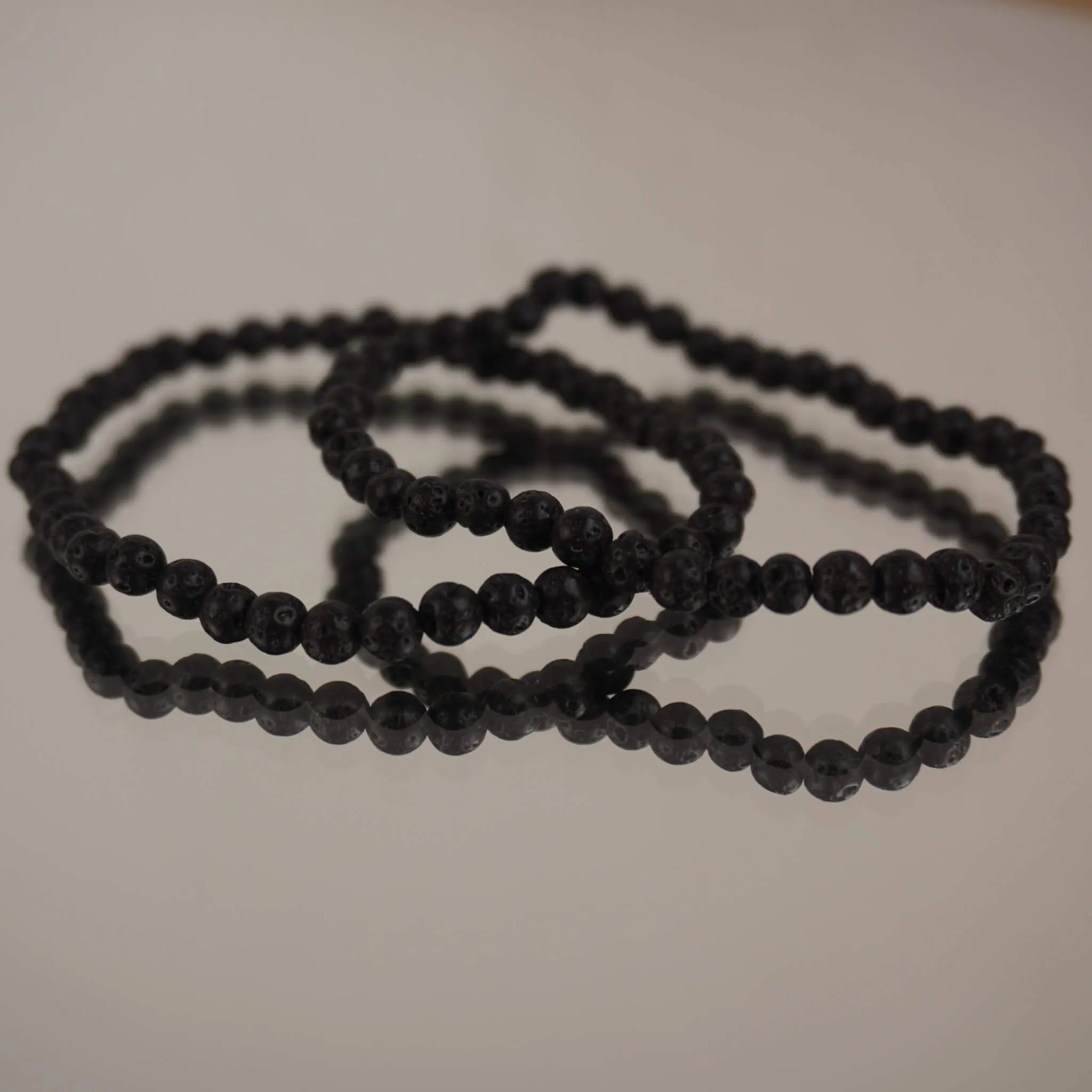 Lavastein Kugelarmband auf spiegelnder Fläche mit feiner Reflexion