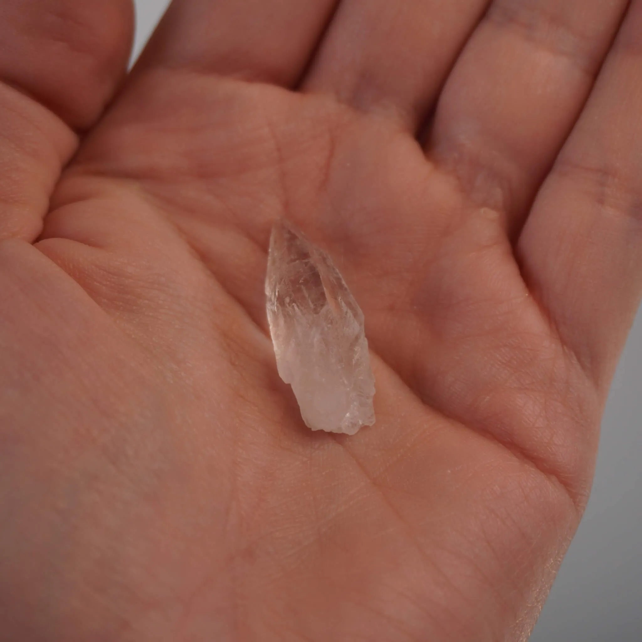 Kleine lemurianische Quarz Spitze in der Hand zur Größenansicht