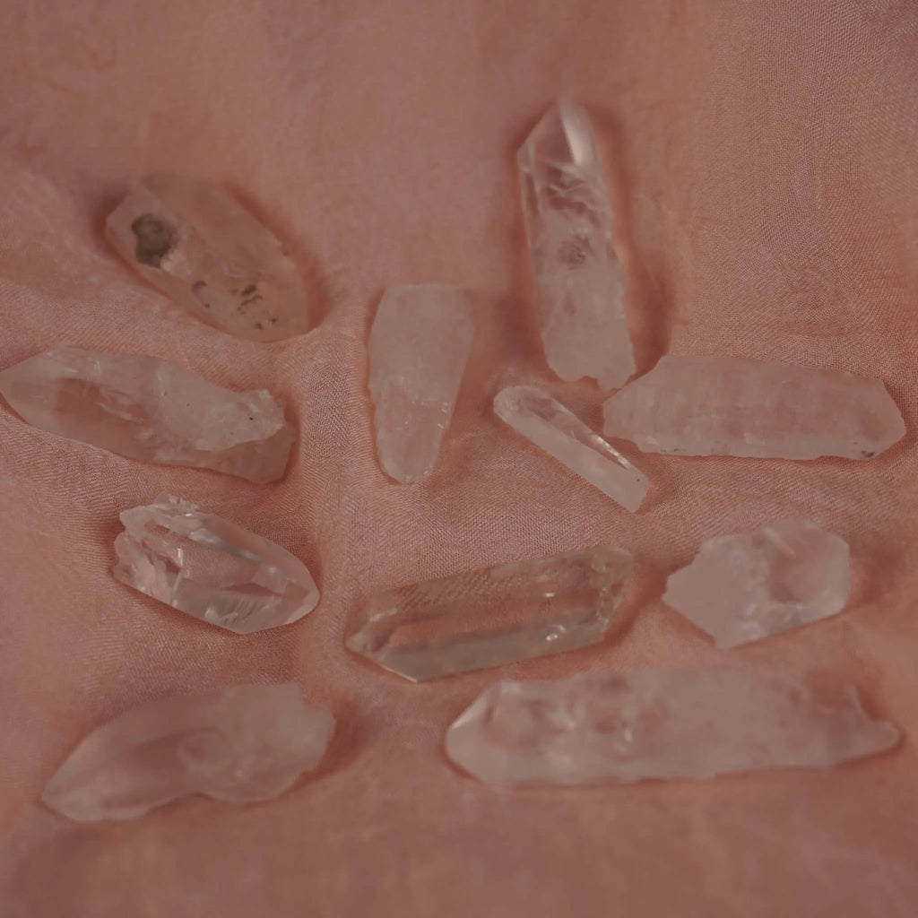 Mehrere lemurianische Quarz Spitzen auf rosa Stoff locker verteilt